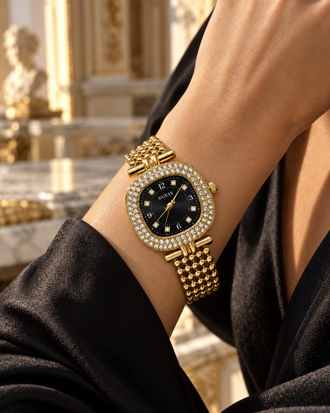 Guess women's watch on wrist Lebanon - gold-tone cushion case with double crystal bezel, black sunray dial with crystal markers, beaded gold ball-chain bracelet